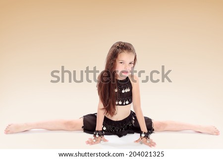 Girl in Eastern dance costume performs twine.Happiness concept,happy childhood