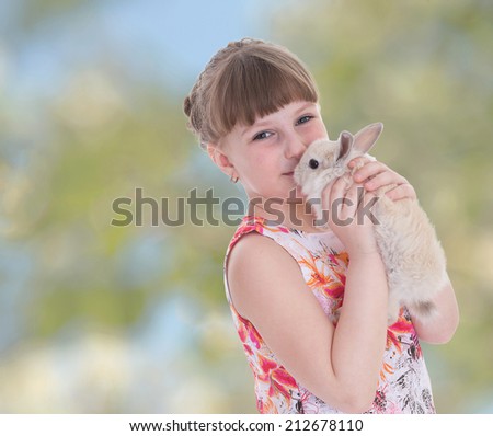 Charming girl kisses rabbit.The concept of child development, education, recreation
