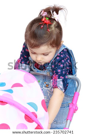 little girl with a doll stroller rolls.White background, isolated photo.