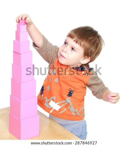 Little boy learn to put pink pyramid in Montessori kindergarten-isolated on white background