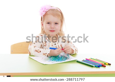 Portrait of blond little girl sitting at the table and draws markers-Isolated on white background