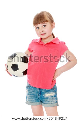 Beautiful little blonde girl with short bangs and long braids on his head. The girl is dressed in a red top and short denim shorts . In the hand of a girl holding a soccer ball , close-up-Isolated on