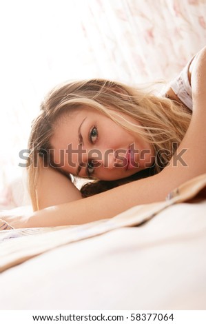 Beautiful young woman relaxing in the bedroom in the morning