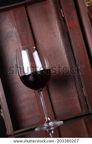 Glass of red wine with a wooden case in the background