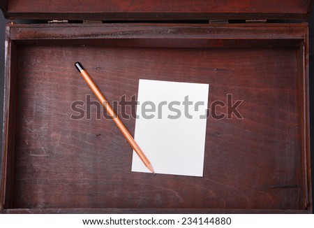 Blank paper and a wooden pencil in an empty wooden case