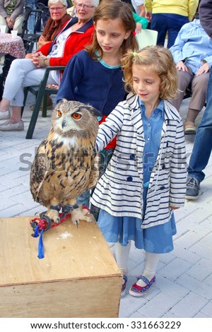 Soest, Netherlands, 26 september 2015, Young girls are petting a wild eagle owl during a falconer show. This eagle owl is the biggest owl in the world
