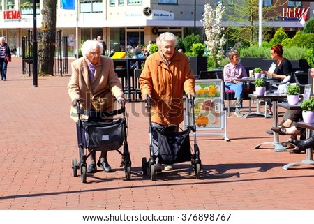 SOEST, NETHERLANDS - April 11. Two old ladies are walking and shopping with wheeled walkers in a shopping street on April 11, 2014 in Soest.