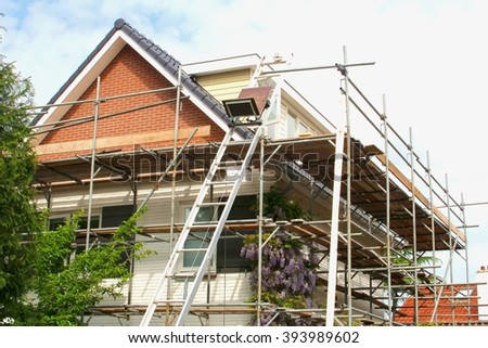 Exterior renovation of a modern house and construction equipments