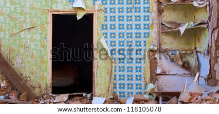 Interior of a abandoned house after shooting down the facade showing old fashioned wallpaper
