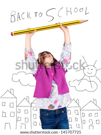 Little girl laughing with arms up holding a big pencil. Drawing of a city in the background. Back to school concept.