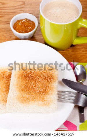 Breakfast with toast, jam and coffee with milk