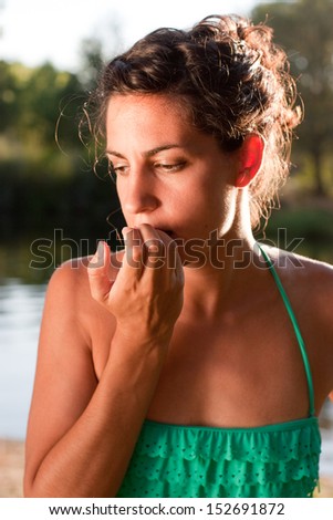 Young girl in bikini biting nails looking worried
