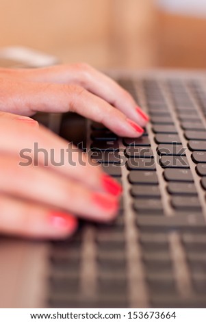Woman hands typing in a keyboard of a laptop