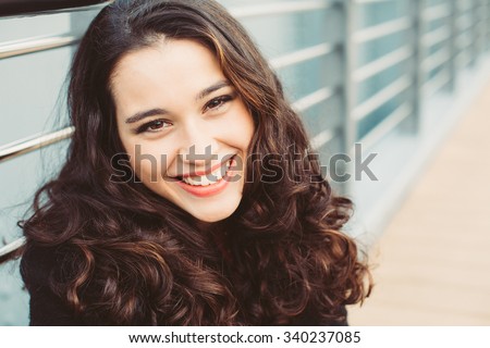Portrait of a gorgeous brunette woman with wavy hair and beautiful smile
