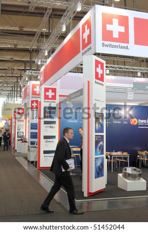 HANNOVER, GERMANY - APRIL 19: stand of switzerland at the hannover industrial fair with businessman rushing by , Hannover Messe April 19, 2010 in Hannover, germany