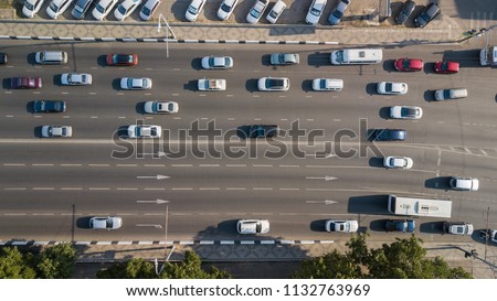 Aerial Drone Flight top down View of freeway busy city rush hour heavy traffic jam highway.  Aerial view of the vehicular intersection,  traffic at peak hour with cars on the road, over the bridge.