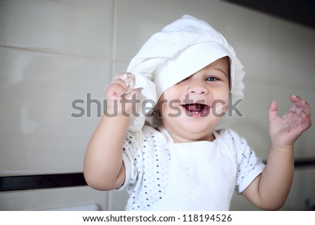 happy cute little baby in a cook cap laughs