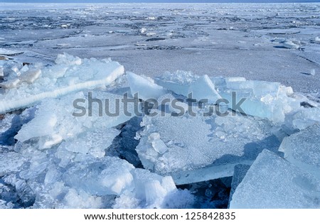 Natural ice blocks breaking up against shore and sea ice during freezing winter weather. Fast ice.