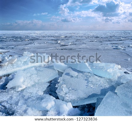Ice floe breaking up against shore with sea ice during freezing winter weather. Fast ice.