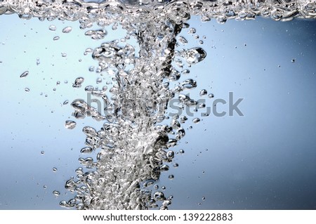 Air bubble stream in water rising to surface.