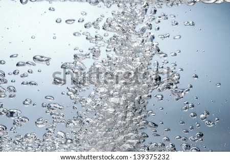 Air bubble stream in water rising to surface.