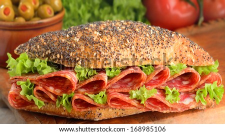 Salami sausage slices on wholemeal bread roll with lettuce.