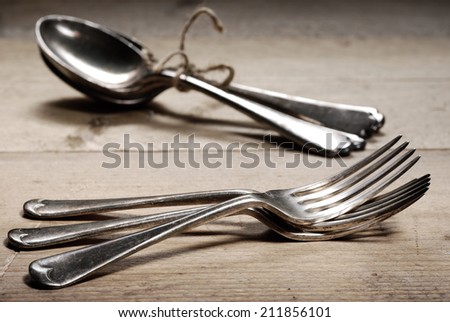 Old silver forks and spoons found at flea market. Tinted black and white with selective focus on foreground forks.