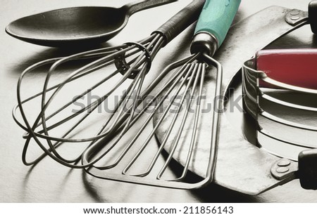 Collection of retro, vintage kitchen utensils. Black and white with original color in wooden handles.