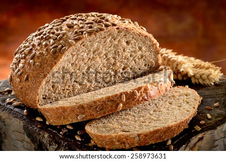 Freshly baked bread made from whole grain, sliced on rustic wooden surface.