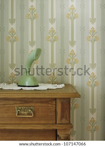 Vintage phone in front of patterned wallpaper