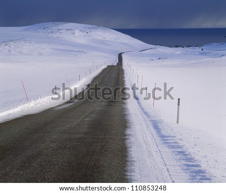 Road by snow-covered landscape