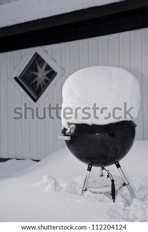 Grill covered with snow in front of house