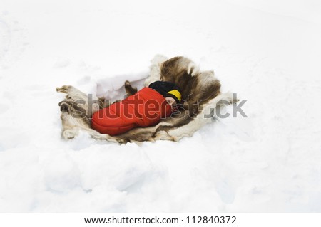 A baby sleeping in a sleeping-bag in the snow, Sweden.