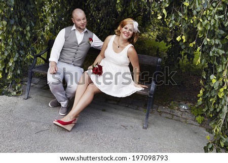 Bride and groom sitting on bench, Uppsala, Sweden