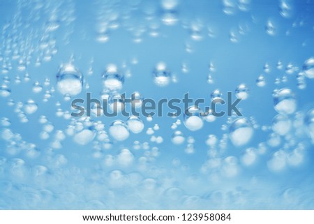 Bubbles of oxygen  in glass of water on a blue background. Mineral water. Water enriched with oxygen.Oxygen. Water.Water background. Macro.Texture.Glass with water.Natural.