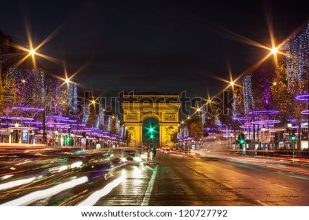 Evening traffic on Champs-Elysees in front of Arc de Triomphe Paris France at Christmas Time Evening traffic on Champs-Elysees in front of Arc de Triomphe Paris France at Christmas Time