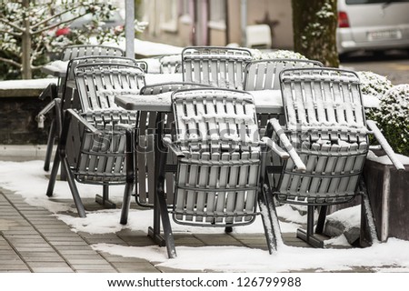 chairs and tables covered by snow of a restaurant in zurich, Switzerland
