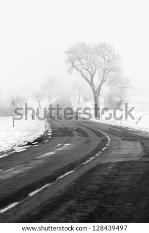 Country road in Lorraine, between the snow covered fields