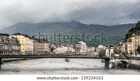 Bridge through the Isere river in Grenoble, Alps on the background