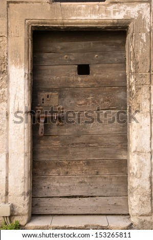 old wooden door of ancient prison in Arles, France