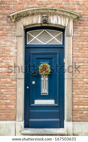 Old blue wooden door on a red brick wall, Bruges, Belgium