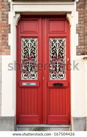 Old red wooden door in Bruges, Belgium