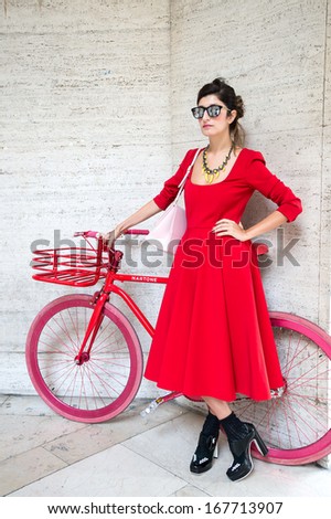 PARIS - OCTOBER 2: Stylish woman with red dress on October 2, 2013 in Paris, France. Paris Fashion Week is a clothing trade show held semi-annually each year in Paris, France.