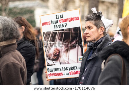 PARIS - JANUARY 7, 2014: People with cow mask protest against the farm-factory near the National Assembly. The farm-factory is condemned by the protestors because of infringement of animal rights.