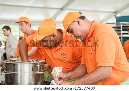 PARIS - MAY 16, 2012: Bakers, in orange clothes, work the flour. The 17th Bread Festival (Fete du Pain) is held in Paris from May 14 to 20, 2012.