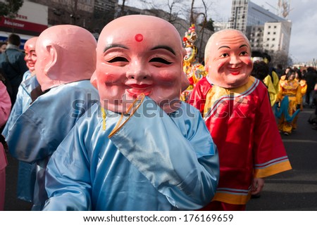 PARIS - FEBRUARY 9, 2014: People with mask in the parade. The Main Chinatown parade is the biggest and most popular of the annual parades for the Chinese new year.