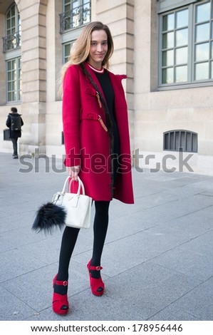 PARIS - FEBRURY 26, 2014: European woman with red coat, white Prada bag and red high heels at the Place Vendome. Paris Fashion Week: Ready to Wear 2014/2015 is held from February 25 to March 5, 2014.