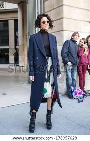PARIS - FEBRUARY 26, 2014: Stylish European woman with sunglasses, blue coat at the Place Vendome. Paris Fashion Week: Ready to Wear 2014/2015 is held in Paris from February 25 to March 5, 2014.