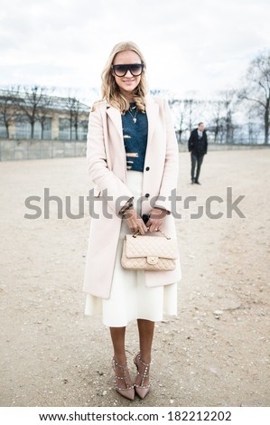 PARIS - MARCH 1, 2014: Stylish European woman with sunglasses and Coco Chanel bag in the Tuileries Garden. Paris Fashion Week: Ready to Wear 2014/2015 is held from February 25 to March 5, 2014.