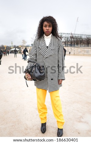 PARIS - MARCH 1, 2014: Stylish black woman with black and white pattern coat in the Tuileries Garden. Paris is one of the capitals of fashion in the world.
